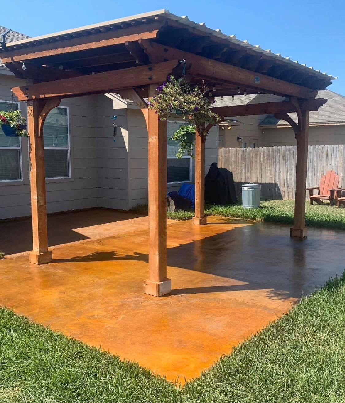 Vivid orange acid-stained patio beneath a cedar pergola