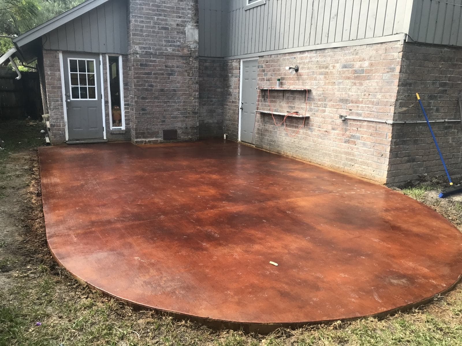 Round acid-stained concrete patio in a back yard