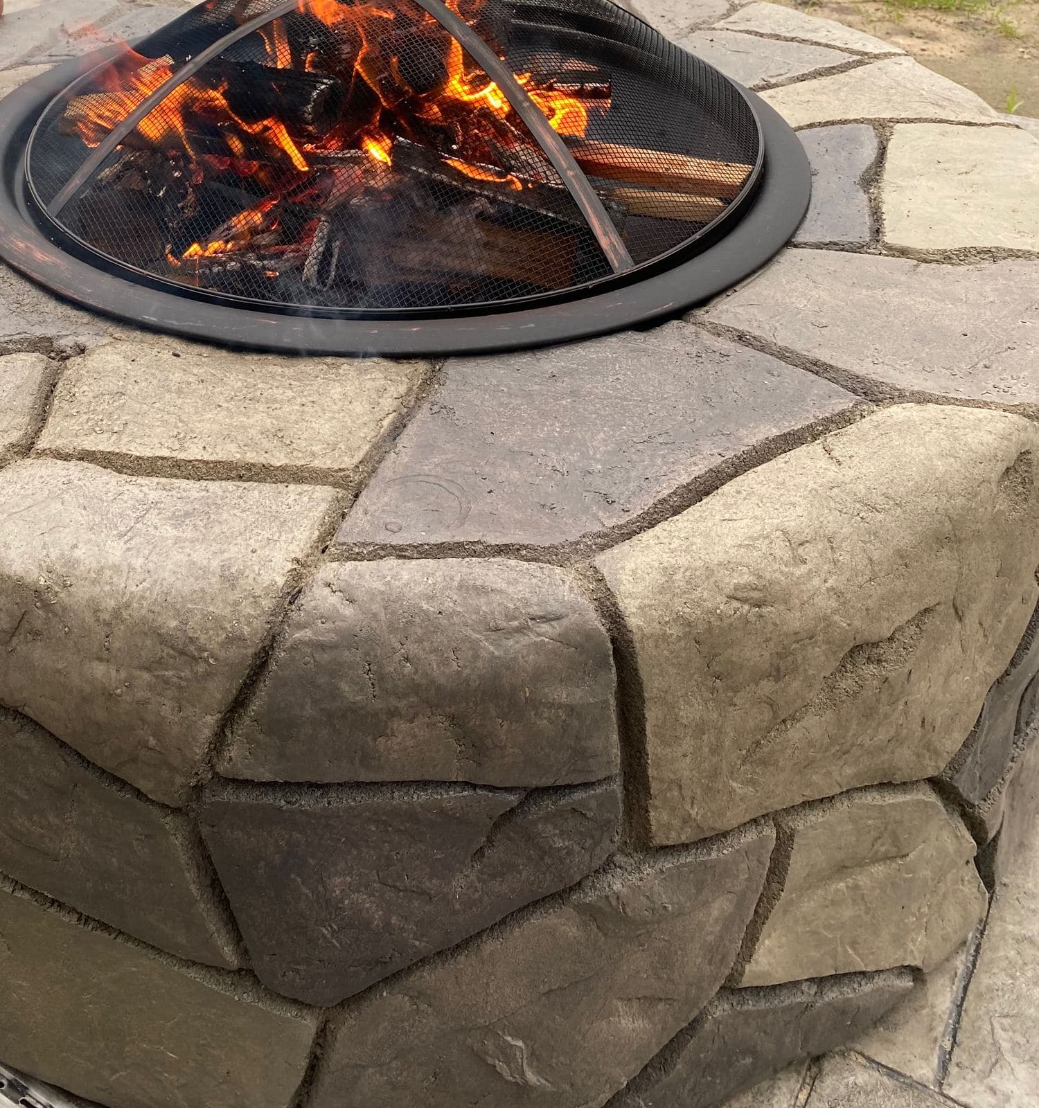Close-up of a wood fire burning in a stone-look concrete fire pit