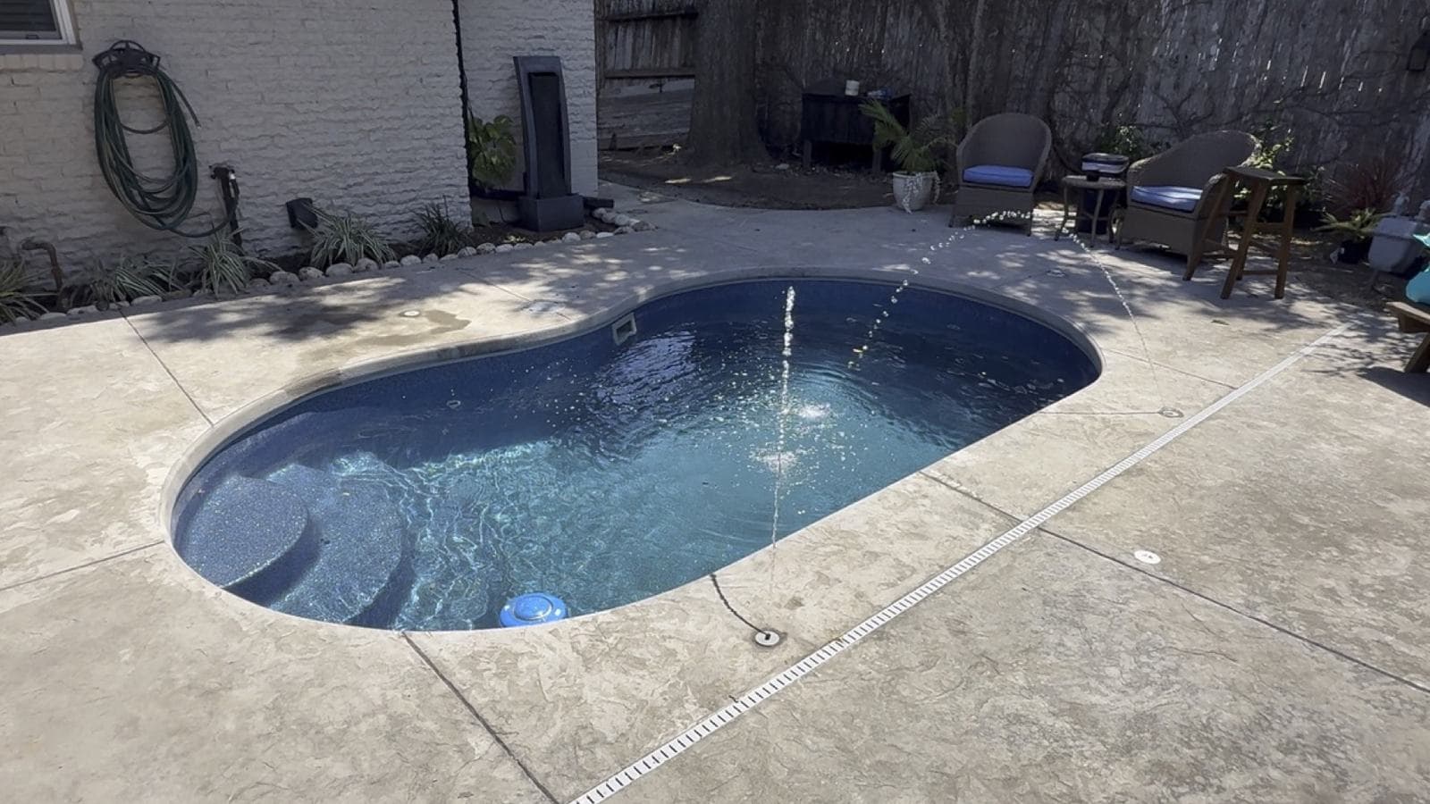 Stamped concrete pool deck around a freeform pool and spa