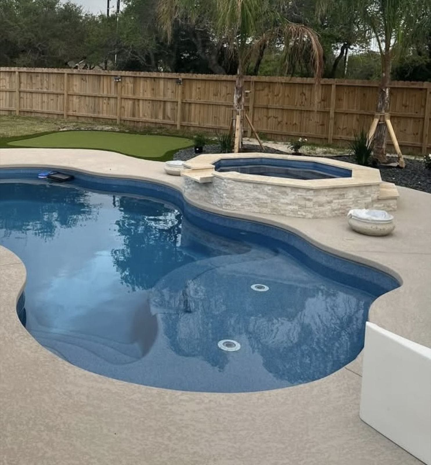Freeform pool and spa with a sprayed knockdown cool deck