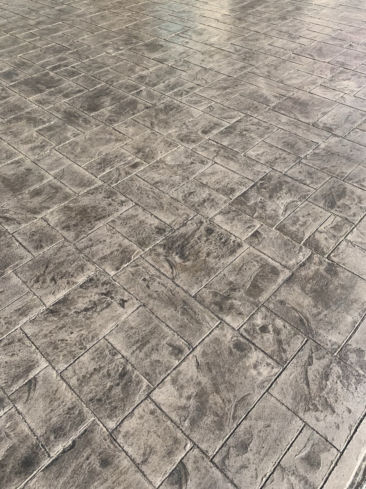Close-up of square-tile-pattern stamped concrete in gray