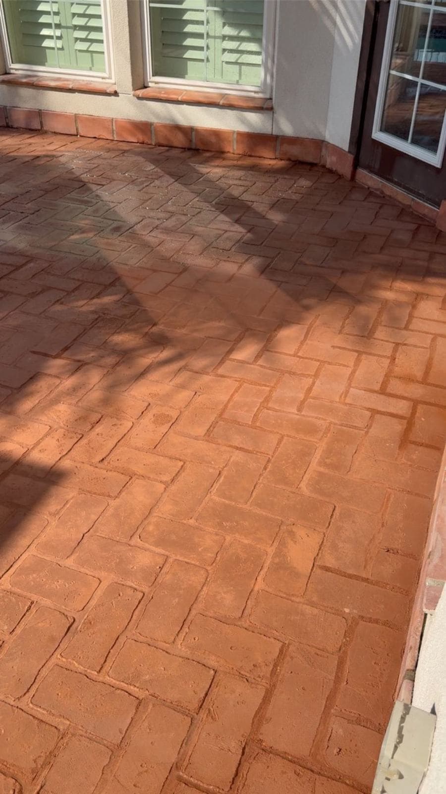 Close-up of red brick-pattern stamped concrete laid in a herringbone bond