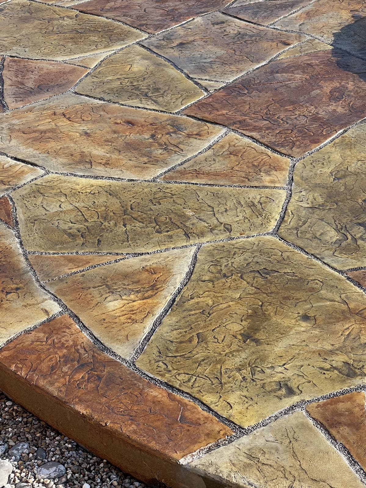 Close-up of tan and gold stamped flagstone with a finished edge
