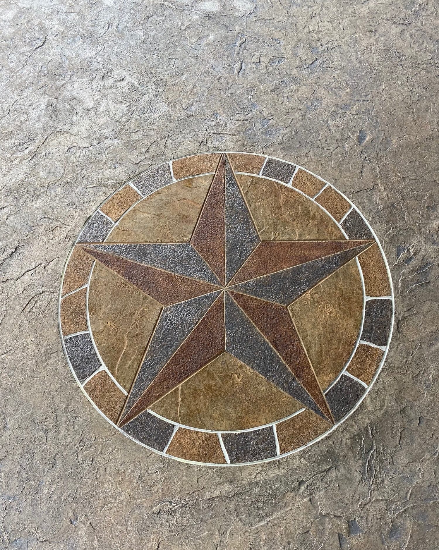 Close-up of a Texas star medallion stamped into tan and gold concrete