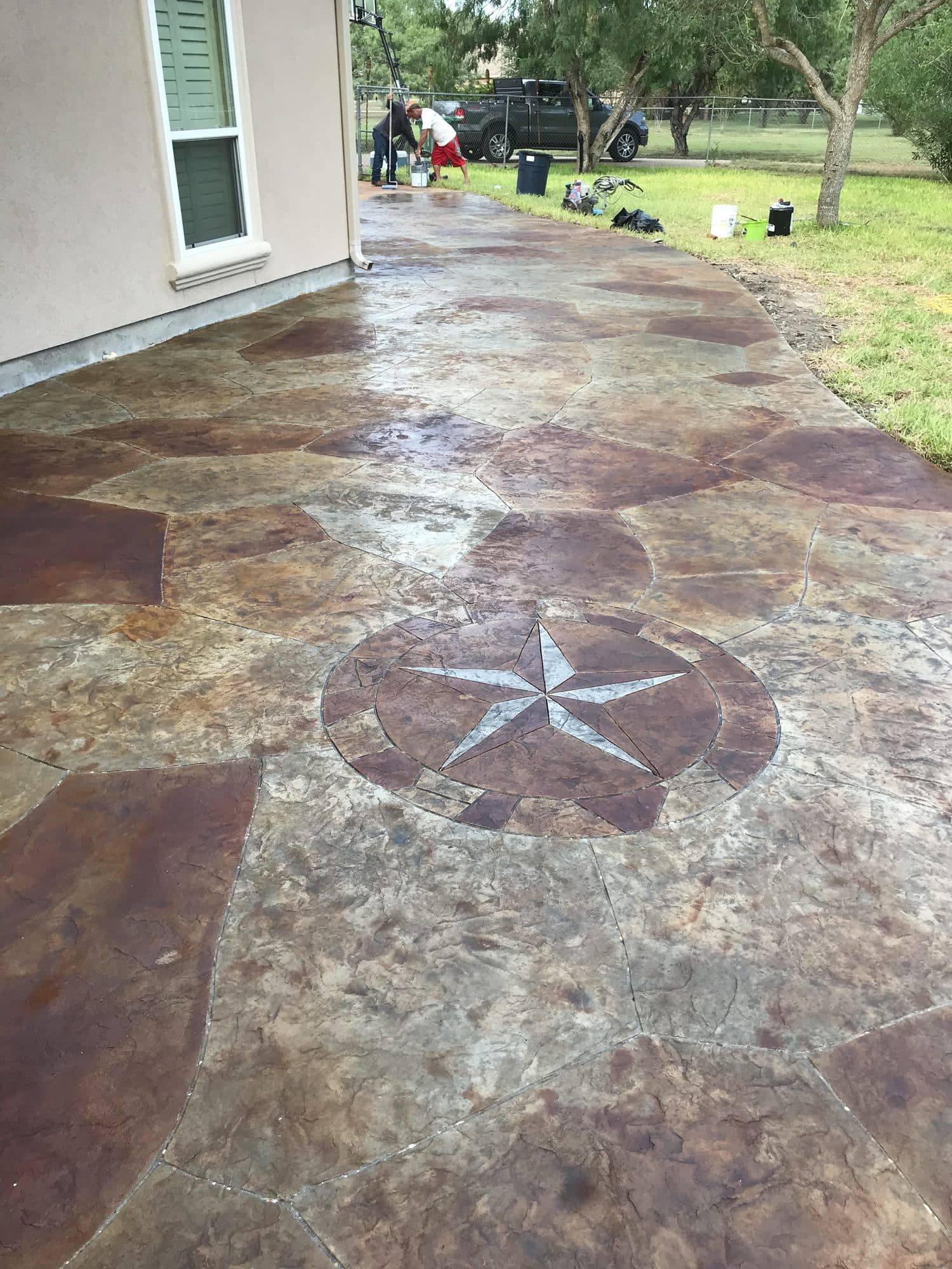 Rust-brown stamped and stained patio with an inset Texas star medallion