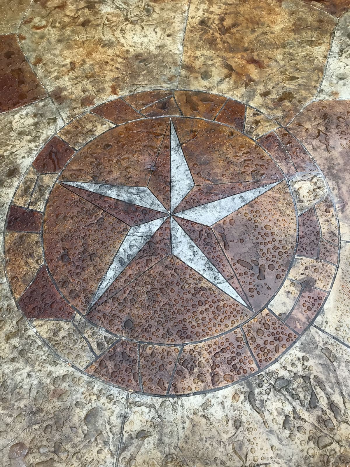 Stamped concrete Texas star medallion set into a stone-textured patio